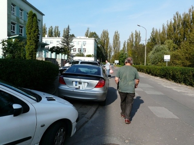 Auta stoją na chodniku, a ludzie idą jezdnią – tak jest na terenie zgierskiego szpitala.