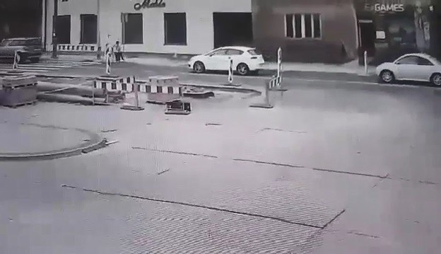 Biały samochód zatrzymuje się przed przejściem dla pieszych
