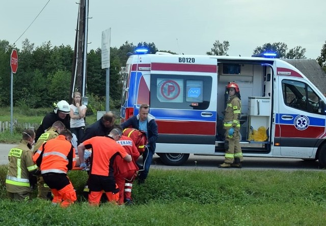 Marek Pikulski (na pierwszym planie, z prawej) pomaga ratownikom wnieść poszkodowanego do karetki pogotowie.