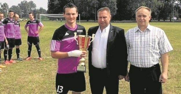 Wiceprezes Świętokrzyskiego Związku Piłki Nożnej Sławomir Trybek (w środku) wręczył Zieleni puchar za awans do "okręgówki".