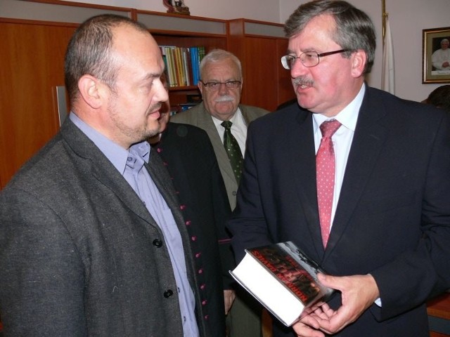Nadkomisarz Aleksy Hamera (z lewej) odbiera nagrodę, książkę z dedykacją z rąk marszałka Bronisława Komorowskiego.