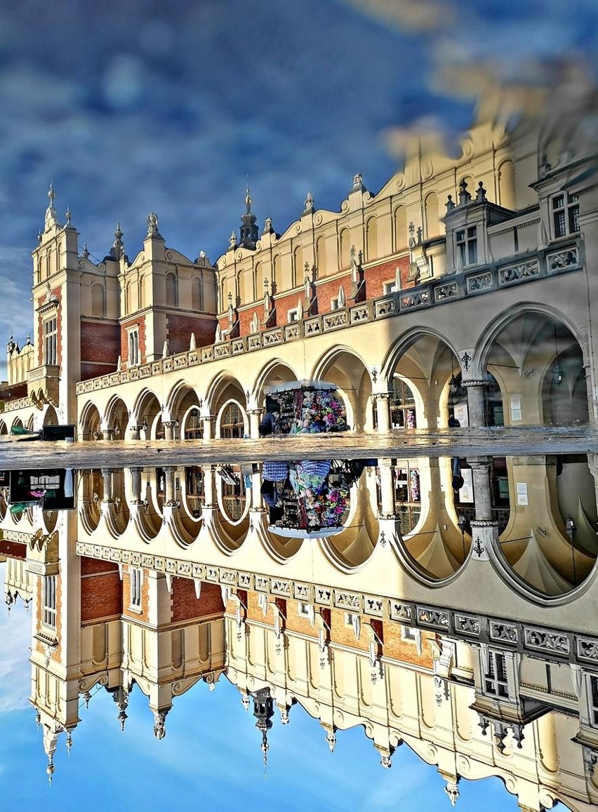 Kraków. Rynek Główny odbity w kałuży. Niecodzienna perspektywa [ZDJĘCIA]