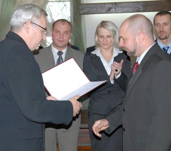 Jacek Kotkowski (od lewej) wręcza Arturowi Kargulewiczowi zaświadczenie o wyborze na radnego Rady Miejskiej w Opatowie.