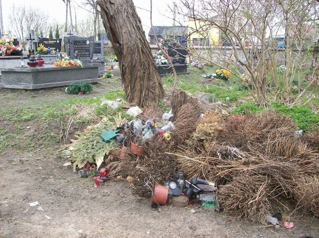 Sterty śmieci piętrzą się przy grobach na cmentarzu w Skrzynnie.