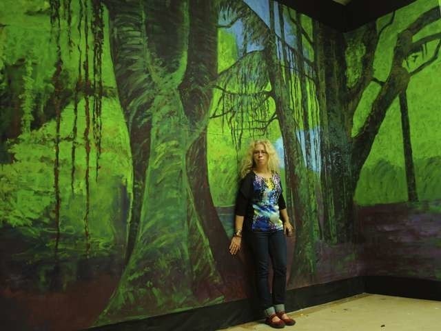 Justyna Jułga przy jednej ze ścian swojego "Rainforest" w Galerii Miejskiej bwa