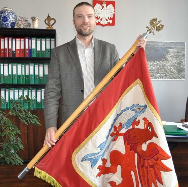 Rzecznik prasowy Konrad Czaczyk prezentuje sztandar miastaSzczecinka. 