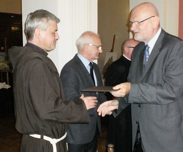 Ojciec Dacjan przyjmuje gratulacje od prezydenta Torunia Michała Zaleskiego