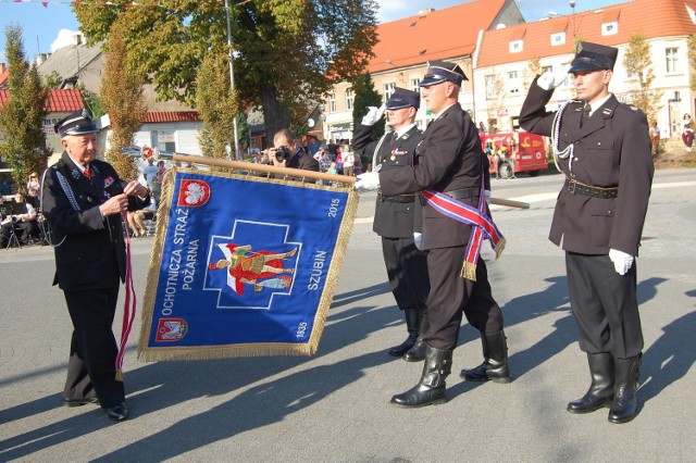 Druh Zdzisław Dąbrowski, prezes zarządu wojewódzkiego OSP, dekoruje nowy sztandar jednostki Złotym Znakiem Związku