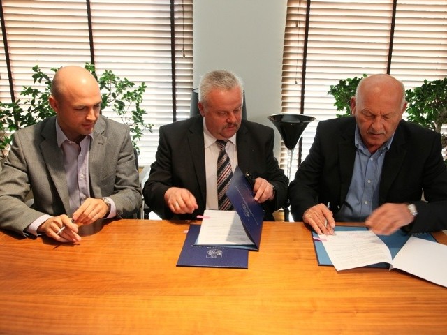 Marszałek Mirosław Karapyta (w środku) podpisuje umowę z wiceprezesami zarządu Asseco Resovii Bartoszem Górskim i Markiem Karbarzem.