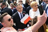 Prezydent Andrzej Duda i pierwsza dama Agata Kornhauser-Duda rozdają flagi. Uroczystości na Placu Zamkowym