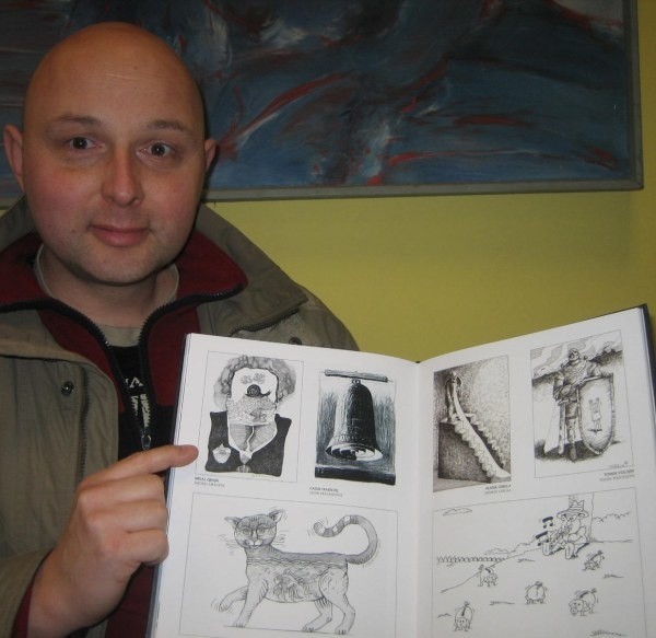 Michał Graczyk pokazuje swój rysunek w azerbejdżańskim wydawnictwie.
