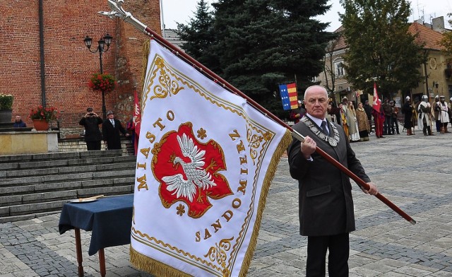 Burmistrz Marek Bronkowski ze sztandarem Sandomierza. Widnieje na nim nowy herb miasta.