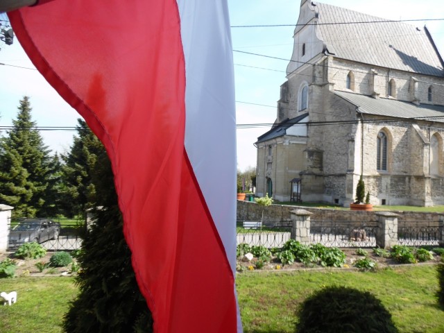 Biało-czerwona flaga przed skalbmierską kolegiatą.