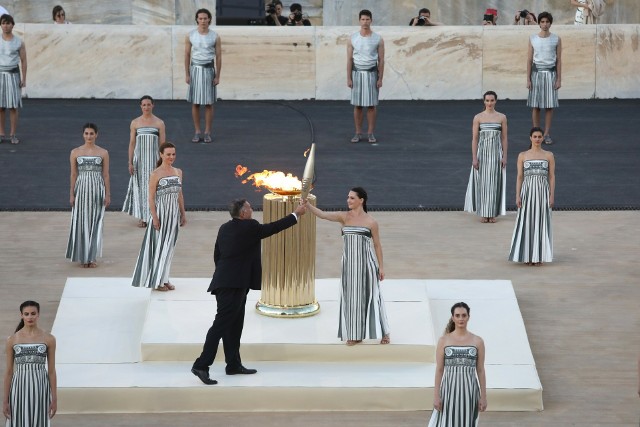 Grecka aktorka Mary Mina przekazuje rozpalony w Atenach olimpijski ogień prezydentowi Greckiego Komitetu Olimpijskiego Spyrosowi Kapralosowi