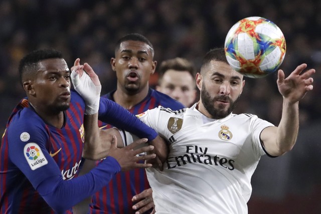 Karim Benzema (na biało) strzelił gola dla Realu w pierwszym meczu półfinałowym Pucharu Króla. Czy w rewanżu też poradzi sobie z obrońcą Barcelony Nelsonem Semedo (z lewej).