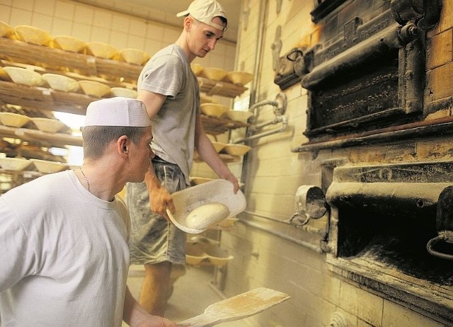 Zbigniew Pawlak  i Michał Kaczorowski wkładają chleb do pieca . To będzie zdrowe, swojskie pieczywo.