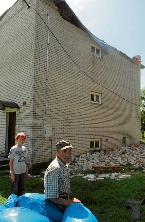 Krystyna i Andrzej Zajegowie przed zniszczonym domem
