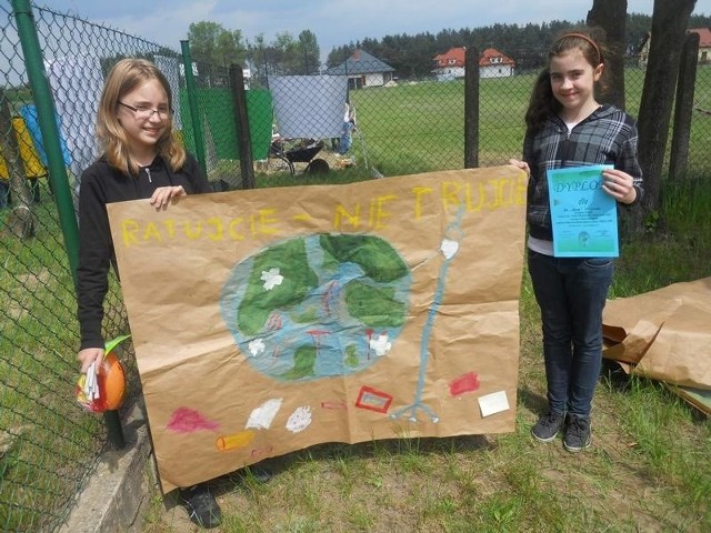 Sara Wiśniewska i Adrianna Kapelak z koła przyrodniczego "Łokietek w PSP w Siniarzewie prezentują wykonany na festynie plakat, za który dostały pierwszą nagrodę