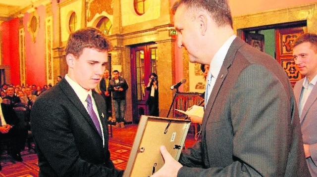 Jacek Kowalczyk, dyrektor w Urzędzie Marszałkowskim, wręcza nagrodę Rafałowi Pragaczowi - laureatowi  66. Olimpiady Matematycznej w Łomży, finaliście Olimpiady Lingwistyki Matematycznej we Wrocławiu.