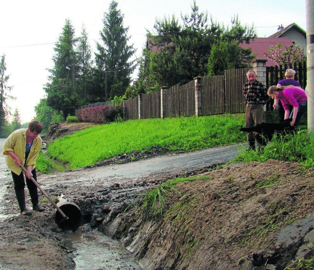 Grażyna Fic sprawdza, czy przepust nie jest zatkany