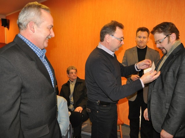 Profesor Tomasz Hesse (w środku) wręcza srebrne odznaczenia "Za zasługi dla polskiego wędkarstwa&#8221; prezesowi koła Mariuszowi Getce (z prawej) i szefowi powiatowej społecznej straży rybackiej Miłosławowi Baranowi (z lewej). 
