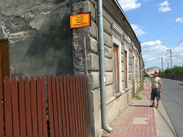 Antoni Andrusik pokazuje wygiętą czołową ścianę bezpańskiego domu.