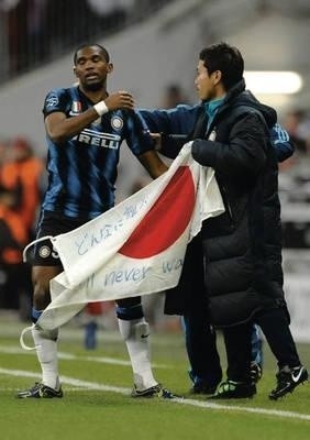 Samuel Eto'o z Interu Mediolan świętuje po zdobyciu gola na znak solidarności ze swoim kolegą z zespołu Yuto Nagatomo i poszkodowanymi w Japonii. Na fladze napis po japońsku i angielsku: "Nigdy nie będziesz sam". Fot. PAP/EPA/Andreas Gebert