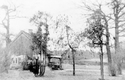 Stary dom pod dębami, stojąca przed nim kobieta to p. Poczmanowa. Luty 1942 r.