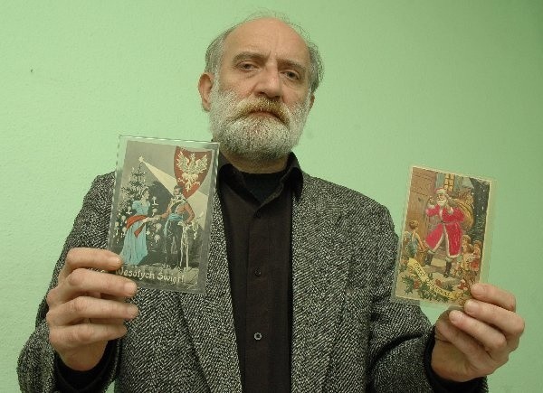 Wojciech Banach pokazuje kartki świąteczne i  noworoczne