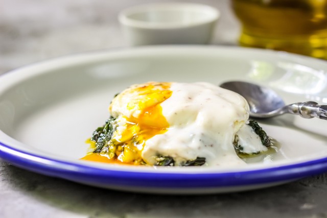 Smakowite jajka po florencku podaje się z sosem holenderskim, grzankami i szpinakiem.