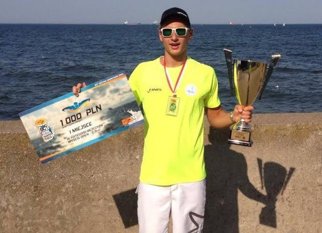Filip Zaborowski z pucharem i czekiem za zwycięstwo w maratonie pływackim w Gdyni.