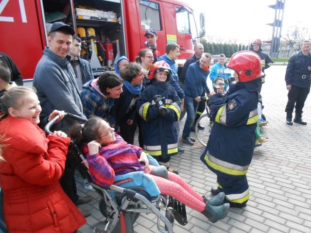 Podopieczni z Ośrodka w Borkowicach sami sprawdzili, jak to jest być strażakiem i przymierzali hełmy, a potem stanęli do zdjęcia.