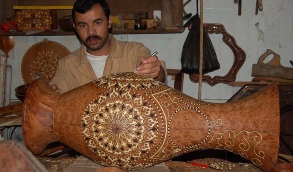 Rzemieślnik pokazuje, jak wyrabia się drewniane mozaiki.