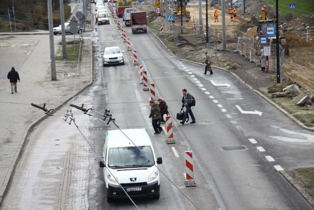 Piesi wybierają najkrótszą drogą przez jezdnię Armii Krajowej z tymczasowego przystanku autobusowego 