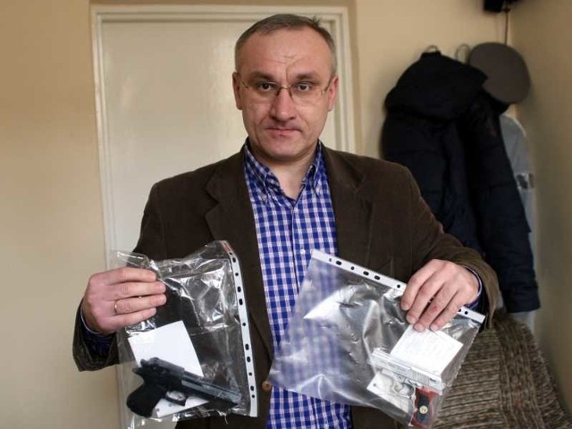 Podkomisarz Leszek Kostecki, naczelnik Wydziału Kryminalnego policji w Tarnobrzegu, prezentuje atrapy broni palnej, którymi posłużyli się sprawcy napadu.