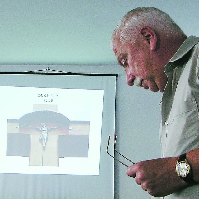 Zbigniew Zarzycki prezentujący radnym zdjęcia z krzyżem. Policja nie dopatrzyła się w nich znamion przestępstwa.