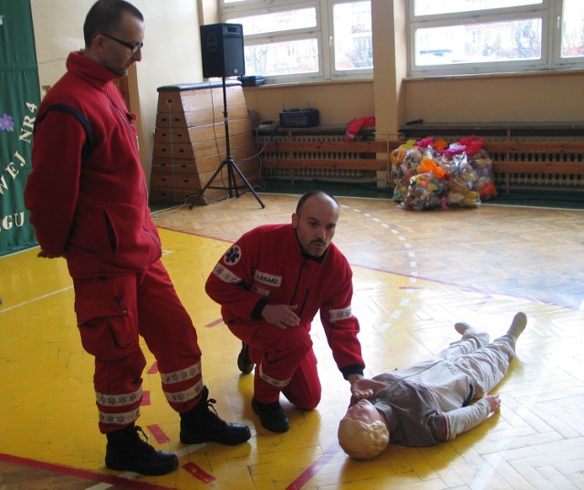 Ratownik medyczny pokazuje uczniom, w jaki sposób można rozpoznać czy ranny z wypadku oddycha.