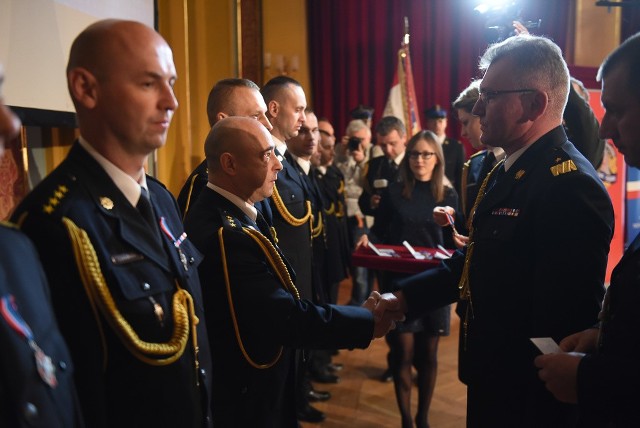 W Dworze Artusa odbyły się toruńskie obchody Dnia Strażaka. Zobaczcie naszą fotorelację z tego wydarzenia. Czytaj także: Ile zarabiają strażacy w Toruniu? Zobacz stawki 2019Srebrną Odznakę ZASŁUŻONY DLA OCHRONY PRZECIWPOŻAROWEJ otrzymali:asp. sztab. Jacek Górskist. kpt. Sławomir Grudzińskist. kpt. Grzegorz MiklaszewskiBrązową Odznakę ZASŁUŻONY DLA OCHRONY PRZECIWPOŻAROWEJ otrzymali:mł. kpt. Przemysław Banieckist. ogn. Przemysław Jankowskist. kpt. Piotr Łęgoszst. ogn. Wiesław Piwowarskimł. asp. Piotr Różyckist. ogn. Paweł SzarszewskiStopień starszego kapitana otrzymali:kpt. Bartosz Kubiakkpt. Grzegorz Miklaszewskikpt. Tomasz Rynkowskikpt. Krzysztof ŻołnaStopień kapitana otrzymał:mł. kpt. Arkadiusz GębkaStopień Starszego Aspiranta otrzymali:asp. Krzysztof Ligajasp. Bartłomiej Marachasp. Łukasz Mądrzejewskiasp. Andrzej Michalskiasp. Krzysztof SzychulskiStopień Aspiranta otrzymali:mł. asp. Krzysztof Bajbakmł. asp. Karol Kowalskimł. asp. Paweł ZagajewskiStopień Starszego Ogniomistrza otrzymali ogniomistrzowie:Łukasz DrewinMichał KwaśniewskiMariusz RutkowskiKrzysztof WójcikStopień Ogniomistrza otrzymali młodsi ogniomistrzowie:Krzysztof ChęczyńskiRafał GilarJarosław GłowackiPrzemysław KurkowskiLeszek KusiowskiPiotr LisewskiRobert ŁotyszPiotr MytlewskiMarcin NogajSebastian RomanowskiDawid SzkodzińskiMaciej WalczyńskiArkadiusz ZakierskiStopień Młodszego Ogniomistrza otrzymali starsi sekcyjni:Arkadiusz DerkowskiPatryk PawłowskiAndrzej StraubDawid WiśniewskiStopień Starszego Sekcyjnego otrzymali sekcyjni:Arkadiusz BojarskiMarcin GęsickiBłażej JóźwickiMaciej KrzeszewskiMarcin KucharskiKrzysztof NieradkaKamil PleskotŁukasz RentflejszAndrzej RóżyckiMichał SerkowskiPatryk SmolarzPaweł SyrockiRafał SzrejterTomasz UździńskiRadosław ZielińskiDawid ZiemińskiStopień Starszego Strażaka – otrzymali strażacy:Paweł JachowskiMariusz KowalskiMichał RaciniewskiSzymon SurowiecMikołaj SzulcZłotym Medalem „Za zasługi dla pożarnictwa”dh Mirosław Graczykst. ogn. Rafał JasienieckiSrebrnym Medalem „Za zasługi dla pożarnictwa”asp. Wojciech Charygast. ogn. Wiesław PiwowarskiZa wzorową postawę i wybitne osiągnięcia w realizacji zadań służbowych Komendant Główny Państwowej Straży Pożarnej przyznał DYPLOM.Otrzymał go:- st. kpt. Sławomir Grudziński.Podziękowania od Michała ZALESKIEGO Prezydenta Miasta Torunia.1. asp. sztab. Jacka Górskiego2. mł. bryg. Dariusza Fabisiaka3. st. kpt. Piotra Łęgosza4. st. ogn. Annę Niewczas5. st. sekc. Dawida ZiemińskiegoPodziękowania od Marka Olszewskiego Starosty Toruńskiego.1. kpt. Jarosława Herbowskiego2. kpt. Arkadiusza Gębkę3. st. sekc. Mirosława BulińskiegoPolecamy: Obejrzyj najnowszy odcinek Spod Ekranu