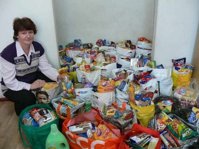 Barbara Lipnicka z Polskiego Czerwonego Krzyża prezentuje paczki żywnościowe, przygotowane z rzeczy zebranych w sklepach.