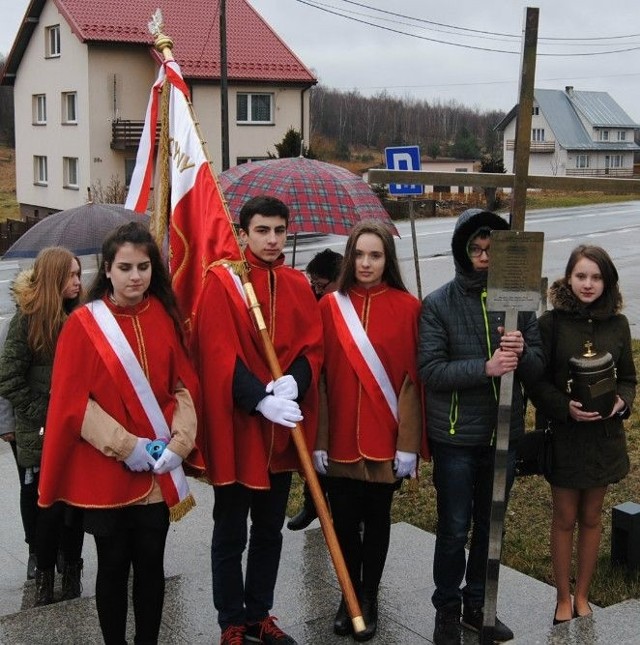 Młodzież szkolna z Konieczna z pocztem sztandarowym szkoły, krzyżem i urną.