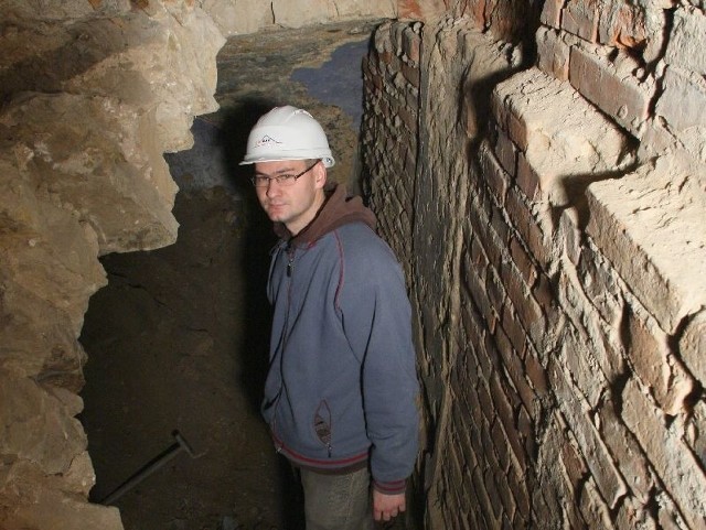 Wejście do nieznanych piwnic pod budynkiem muzeum wskazuje Kamil Skórski, inżynier budowy.