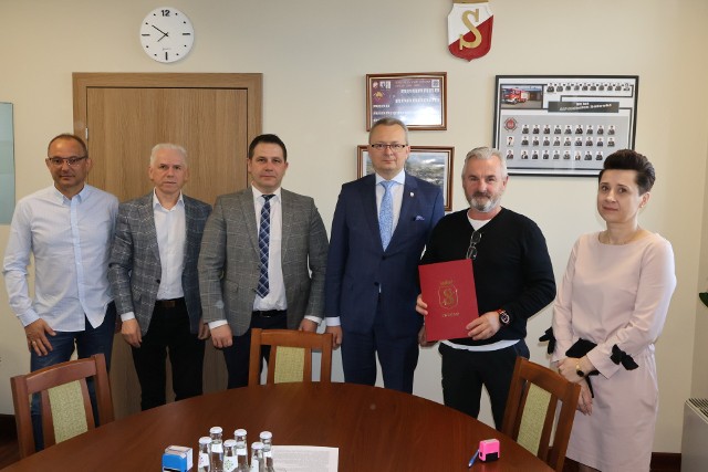 Podczas podpisywania umowy obecni byli przedstawiciele Urzędu Miejskiego na czele z burmistrzem Arkadiuszem Sulimą (czwarty z lewej) i przedstawiciel wykonawcy Dariusz Wziątek (piąty z lewej).
