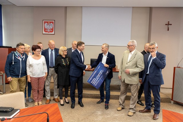 Poseł PiS Bartosz Kownacki w obecności radnych wręczył burmistrzowi Waldemarowi Stupałkowskiemu symboliczny czek