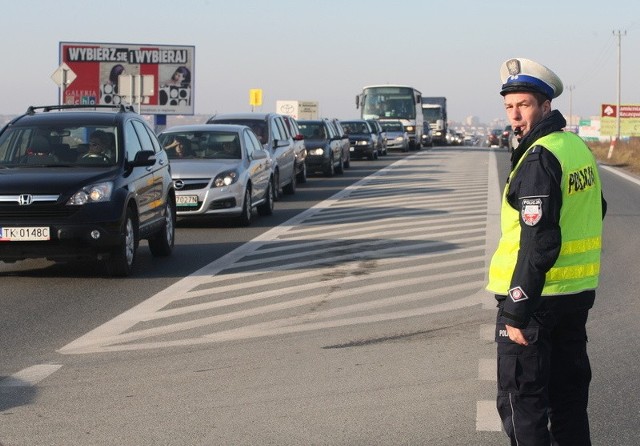Policjanci kierują ruchem na drodze 74 prowadzącej do cmentarza w Cedzynie