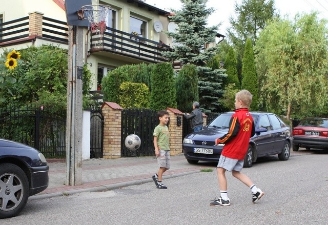 Dzieci z ulicy Kwiatowej grają w koszykówkę na jezdni.