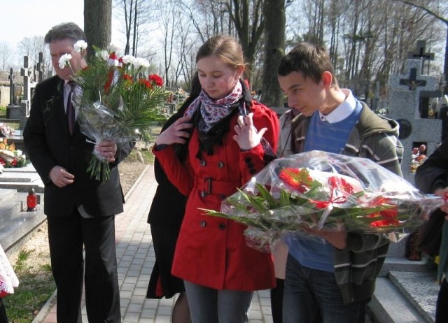Uczestnicy konkursu i  goście złożyli kwiaty i zapalili znicze na grobie Wiktora Ignacego Godlewskiego na cmentarzu w Jasienicy