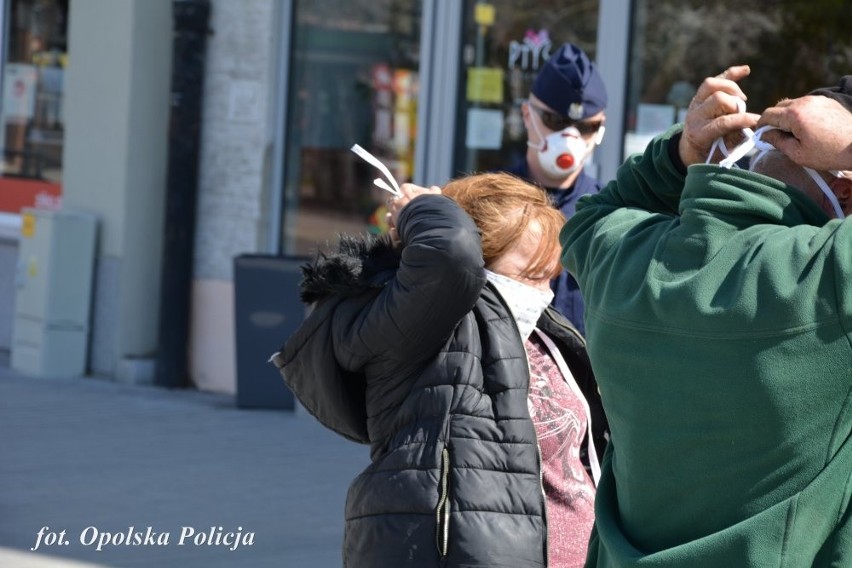 Opolscy policjanci rozdają maseczki na ulicach miasta.