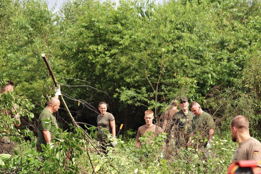 Polscy i niemieccy żołnierze sprzątają teren obozu w...