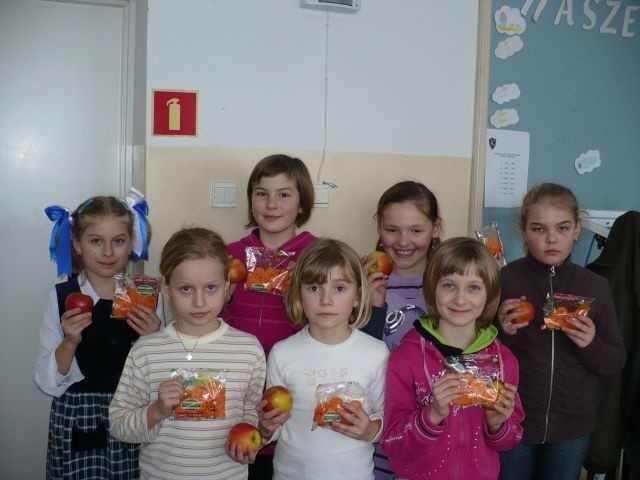 Zadowolone dzieci ze Szkoły Podstawowej w Adamowie, w gminie Brody, prezentują owoce i soki.