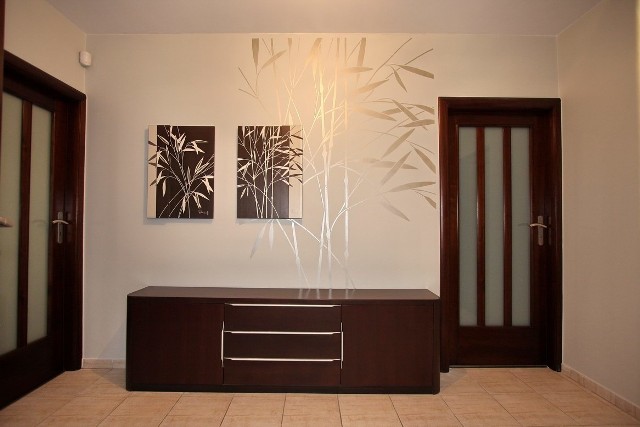 Bambus na ścianieDuży, srebrny szablon bambusowy dobrze komponuje się na tle ciemnych mebli i futryn.